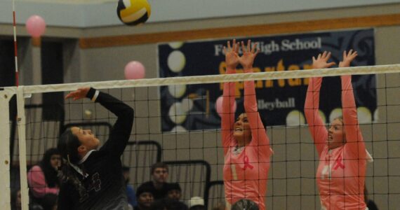 Spartans Erika Williams (left) and Keana Rowley go for the block of a Raymond-South Bend hit Oct 17 in the Spartan Gym as Forks wears pink in awareness of cancer. The Ravens took three straight sets by very close scores. Photo by Lonnie Archibald