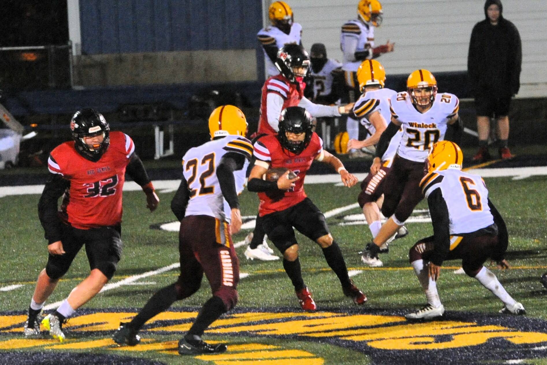 Neah Bay’s JoJo Wimberly looks for running room against Winlock during this playoff game held in Forks. An ankle injury early in the state 1B semifinals, over the weekend, limited his play. Photo by Lonnie Archibald