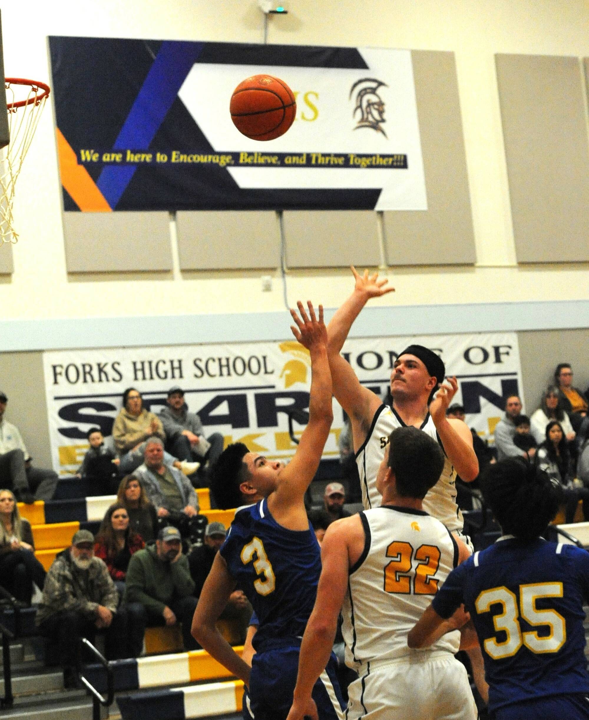 Forks’ Senior Landin Davis takes a shot over Chief Leschi defenders while Spartan Brody Lausche looks on during Senior Night at Forks High School. Photo by Lonnie Archibald