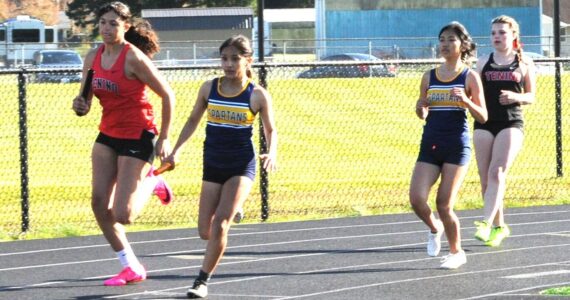 Spartan Marysleidy H Beltran took the handoff from teammate Moli Luong in the first leg of the 4x100 relay won by Forks. Finishing the race, not shown, are Alie Coons and Natalie Horejsi. Photo by Lonnie Archibald