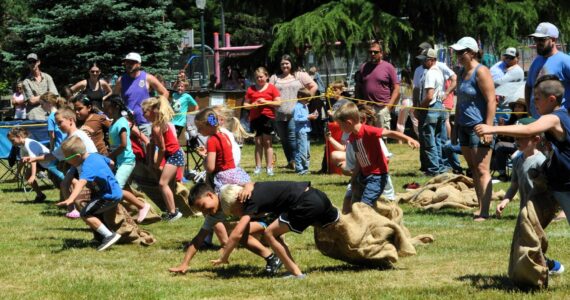 These 6-7-year-olds learn that it takes much skill to keep running with your partner during the three-legged races. Photo by Lonnie Archibald