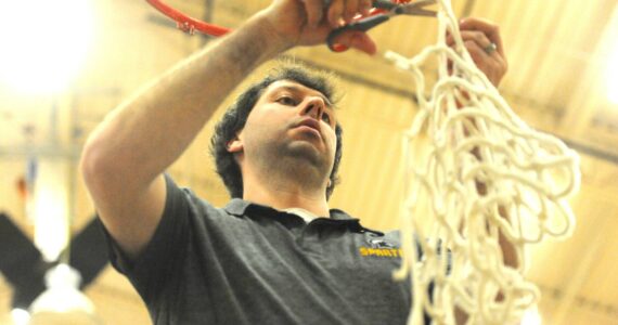 Photo by Lonnie Archibald
Spartan head coach Keith Weekes cut down the remainder of the net after the varsity boys had each taken a strand. The Forks boys won the Pac 2B league with a win over North Beach at home on Senior night.