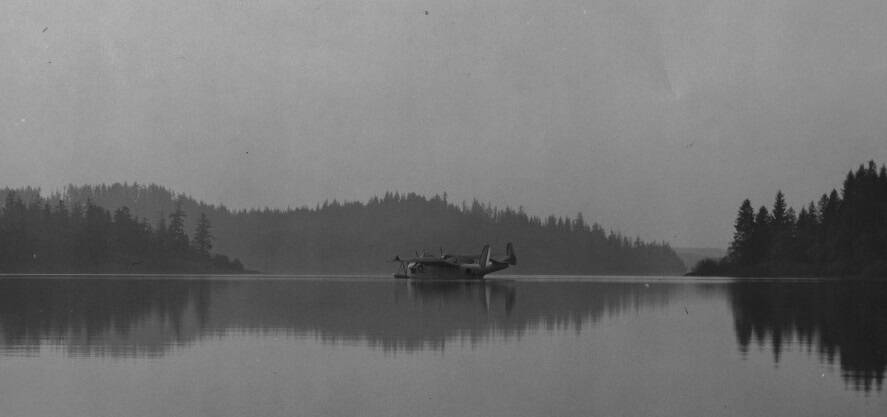 Keen mentioned in the talk float planes on Lake Ozette; here a plane sits on Lake Ozette. During the war many sites along the Sound were scoured for an appropriate small seaplane base, including Lake Ozette, Indian Island, Keystone Harbor, and Penn Cove. The Lake Ozette site never got off the water.