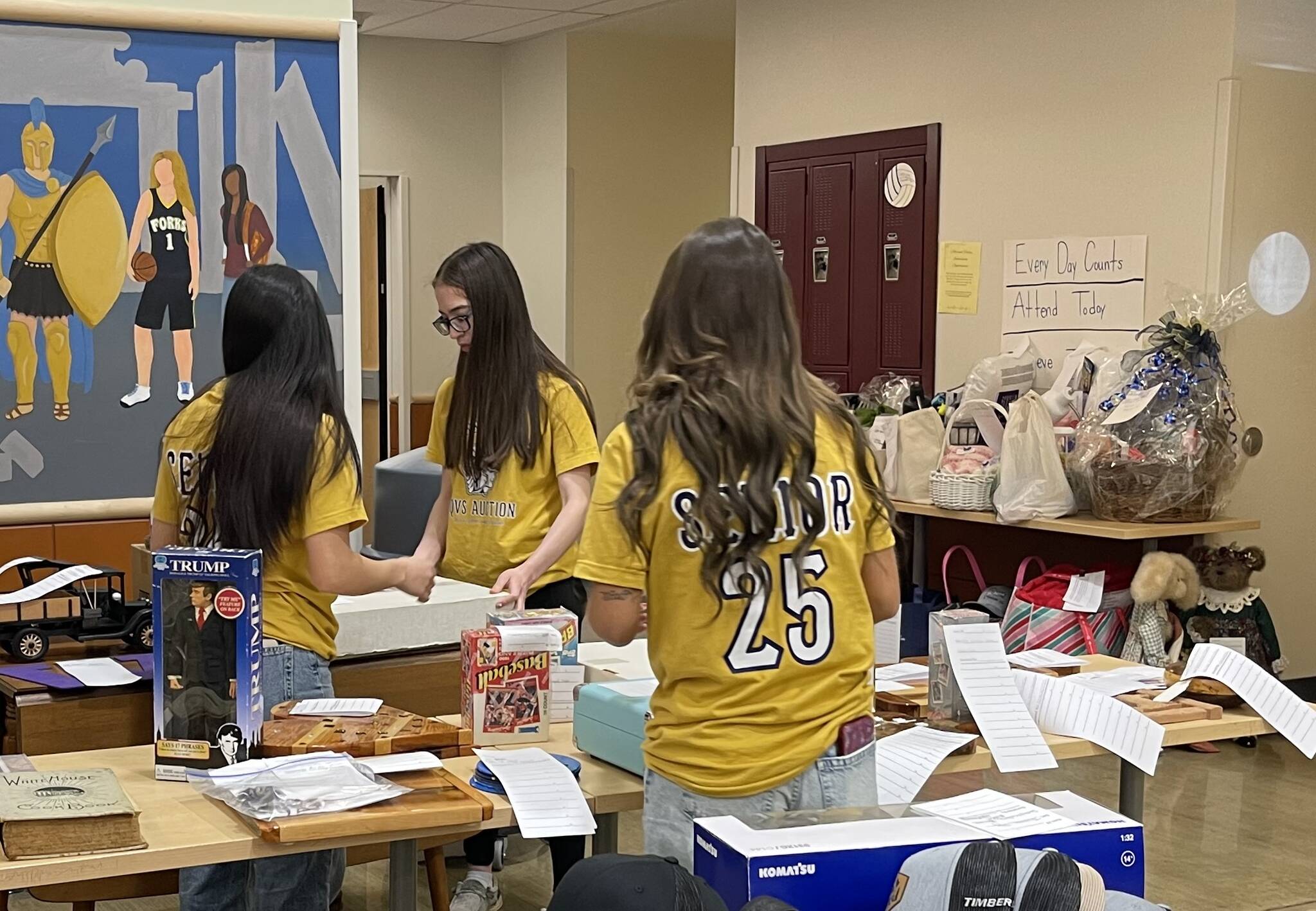 Photo Christi Baron
Senior class of 2025 members worked hard over the two days. Here a group is selecting some of the next items to go up for bid. Everything from farm fresh eggs, to goats to antique sewing machines, artwork, and more were auctioned off over the two days.
