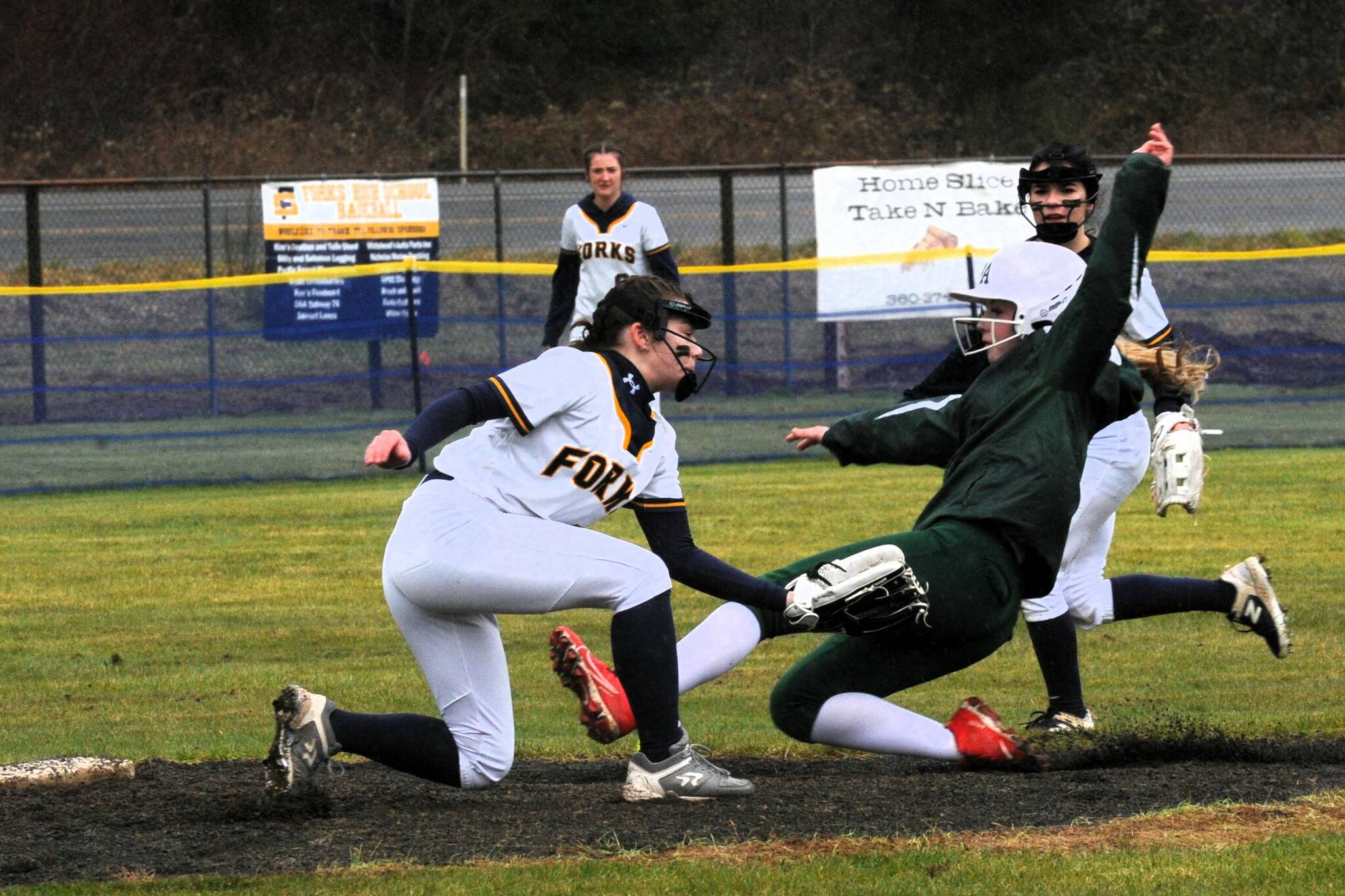 Photos by Lonnie Archibald
Forks shortstop Kylie Hull tags the Roughrider runner out at second while second baseman Kinley Rondeau backs up the play.