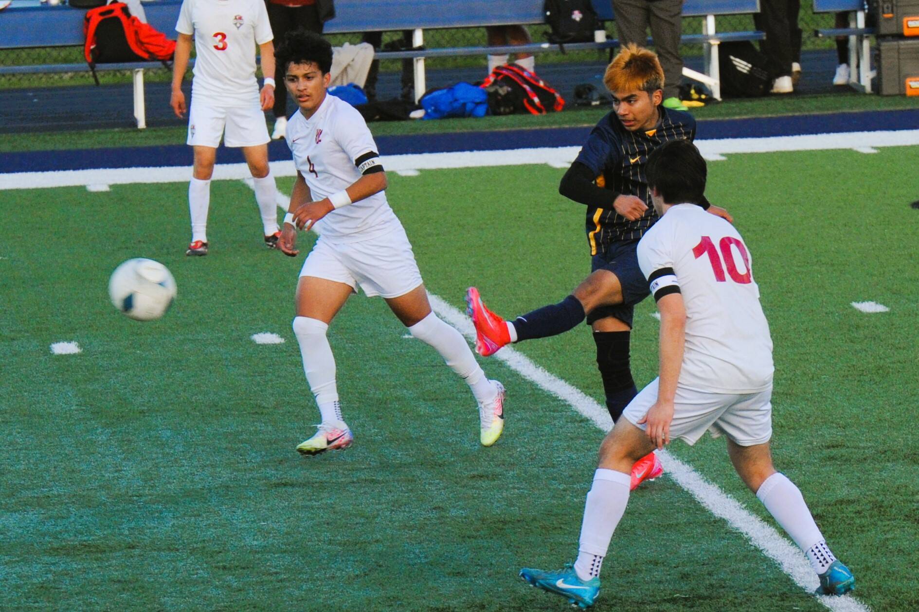 Left, Washington State wrestling champ Abraham Montealegre also competes in soccer, as is seen here where he kicks between Grizzlies Alan Torres and Michael Garcia Thursday, April 3 at Spartan Stadium.