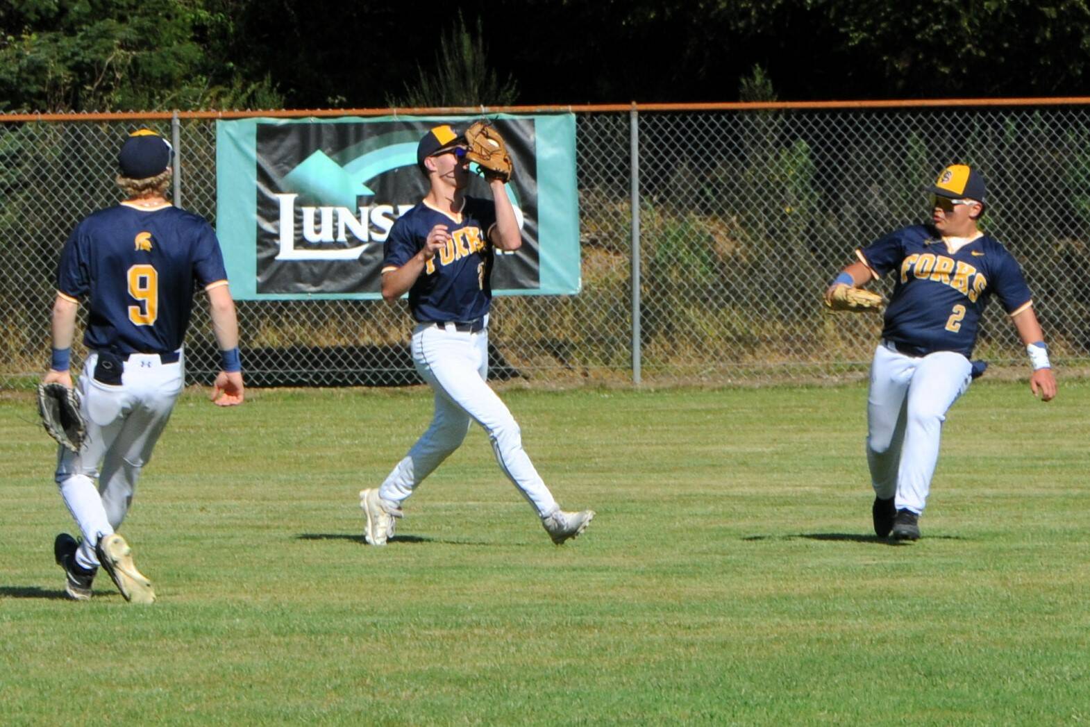 Photo by Lonnie Archibald
Spartan Kingston Steffen came a long way from center field to make this catch of a fly ball between teammates Landen Olson (9) and Cordel Horejsi.