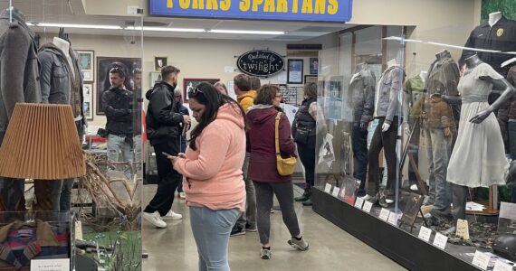 Edelweiss Air’s media delegation, hosted by SWT and the Port of Seattle, visited Forks on May 2 with stops at the Sasquatch Store/Museum and Forever Twilight in Forks Collection as part of a regional tour promoting new Zurich-SEA direct flights. Here the group looks over the FTF Collection as Forks Chamber Executive Director Lissy Andros shres information about the Twilight memorabilia. Photo Christi Baron