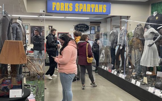 Edelweiss Air’s media delegation, hosted by SWT and the Port of Seattle, visited Forks on May 2 with stops at the Sasquatch Store/Museum and Forever Twilight in Forks Collection as part of a regional tour promoting new Zurich-SEA direct flights. Here the group looks over the FTF Collection as Forks Chamber Executive Director Lissy Andros shres information about the Twilight memorabilia. Photo Christi Baron