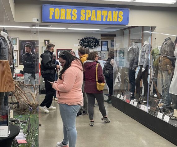 Edelweiss Air’s media delegation, hosted by SWT and the Port of Seattle, visited Forks on May 2 with stops at the Sasquatch Store/Museum and Forever Twilight in Forks Collection as part of a regional tour promoting new Zurich-SEA direct flights. Here the group looks over the FTF Collection as Forks Chamber Executive Director Lissy Andros shres information about the Twilight memorabilia. Photo Christi Baron