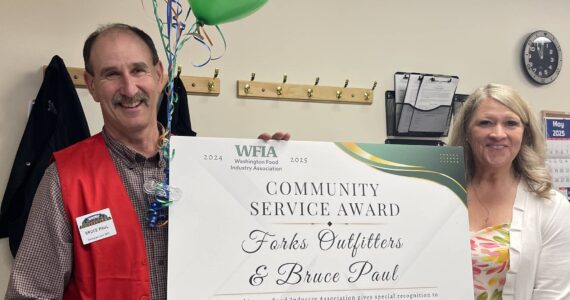 Photo Christi Baron 
WFIA President CEO Tammie Hetrick presents Bruce Paul, owner of Forks Outfitters and Ace Hardware, with the WFIA 2024-25 Community Service Award. The award was presented at a surprise ceremony held May 7 at the store in Forks.