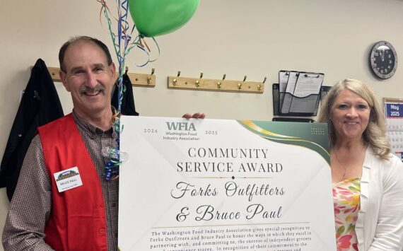 Photo Christi Baron 
WFIA President CEO Tammie Hetrick presents Bruce Paul, owner of Forks Outfitters and Ace Hardware, with the WFIA 2024-25 Community Service Award. The award was presented at a surprise ceremony held May 7 at the store in Forks.