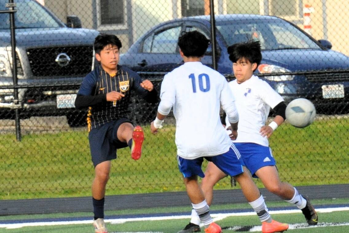 Forks’ Eduardo Calmo, who later scored the second goal for Forks, kicks between two Eagle defenders.