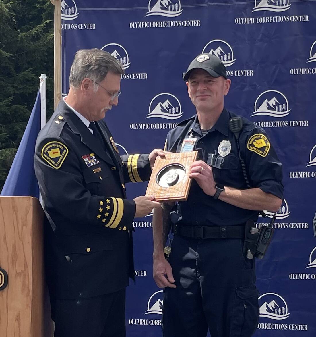 Christopher Lukens smiles as Speer reads words from the plaque he was presented as OCC Correctional Officer of the year. Not pictured Rick Gooding, recipient of the Supervisor of the Year award.