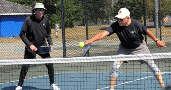 Photo by Lonnie Archibald
One of the fastest growing sports is that of pickleball. While Bert Paul looks on, John Calhoun returns the ball over the net Friday Aug. 1 at Tilicum Park in Forks.