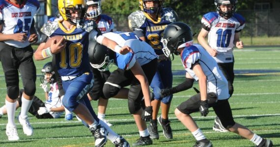 Photo by Lonnie Archibald
FMS Quarterback Logan Dilley (10) made a final cut on his way to a touchdown against Blue Heron of Port Townsend. Helping out is teammate Carlos Bestida (21). Touchdowns were many for these young Spartans.
