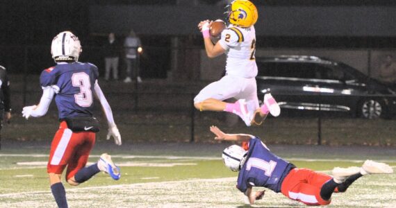 Photos by Lonnie Archibald
Forks’ Estevan Ramos makes the catch as he hurdles the defender at Spartan Stadium, where the Pe Ell/Willapa Valley Trojans defeated the injury-laden Spartans 34 to 9.