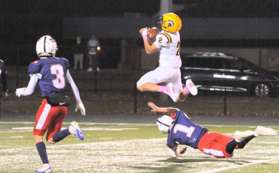 Photos by Lonnie Archibald
Forks’ Estevan Ramos makes the catch as he hurdles the defender at Spartan Stadium, where the Pe Ell/Willapa Valley Trojans defeated the injury-laden Spartans 34 to 9.
