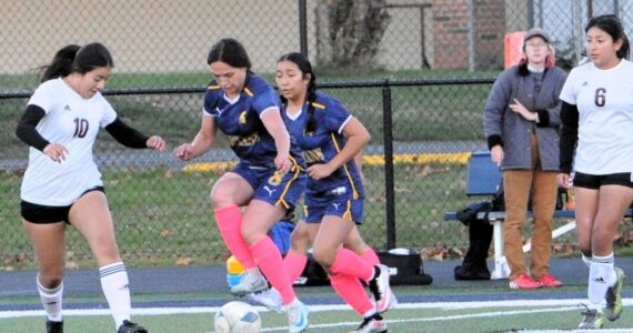Forks’ Jade Blair controls the ball against the Ravens. Also, in the action is teammate Kim Camacho.
