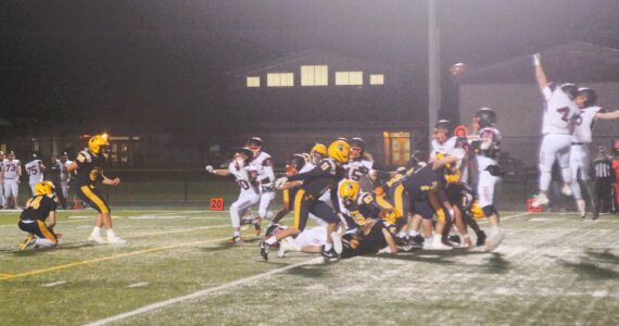 Photos by Lonnie Archibald
Napavine defenders leap high in the fog in an attempt to block a Forks field goal in the first quarter of play. Spartan kicker Mario Reyes kicked it through the uprights, however, giving the Spartans a three-point lead. The Tigers roared back, however, defeating Forks 20 to 15 in a hard-fought contest.