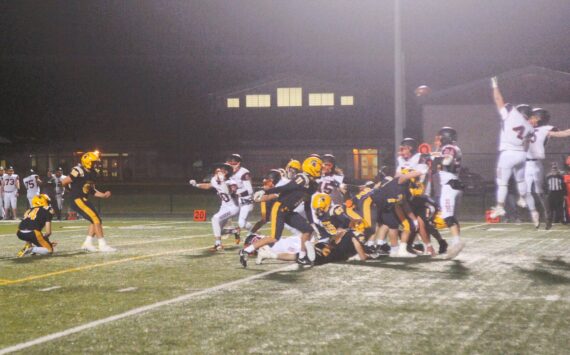 Photos by Lonnie Archibald
Napavine defenders leap high in the fog in an attempt to block a Forks field goal in the first quarter of play. Spartan kicker Mario Reyes kicked it through the uprights, however, giving the Spartans a three-point lead. The Tigers roared back, however, defeating Forks 20 to 15 in a hard-fought contest.