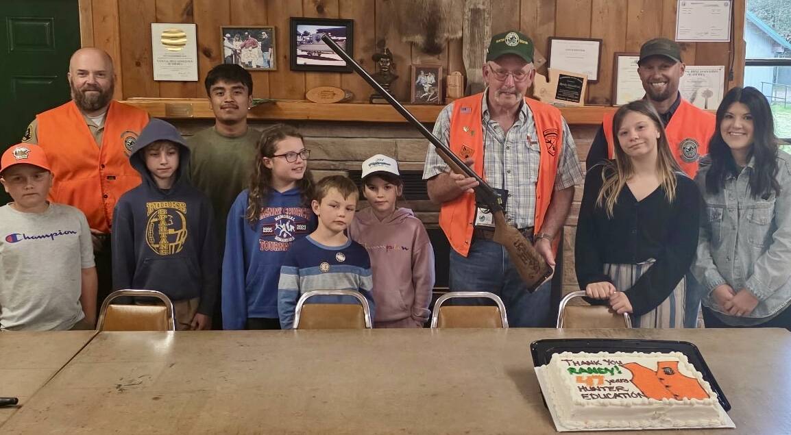 Submitted photo
After almost 50 years of volunteering with the Hunter Education program with the West End Sportsman’s Club, Randy Mesenbrink has decided to retire. “I felt I had a good replacement to take over, so it felt like the right time,” Mesenbrink said. Randy is seen with his last class in this photo, holding a firearm he was presented and of course he got cake! Jason Earls is on the far left and Ty Leppell on the far right. Hunter Education is a program provided by Washington State Fish and Wildlife.