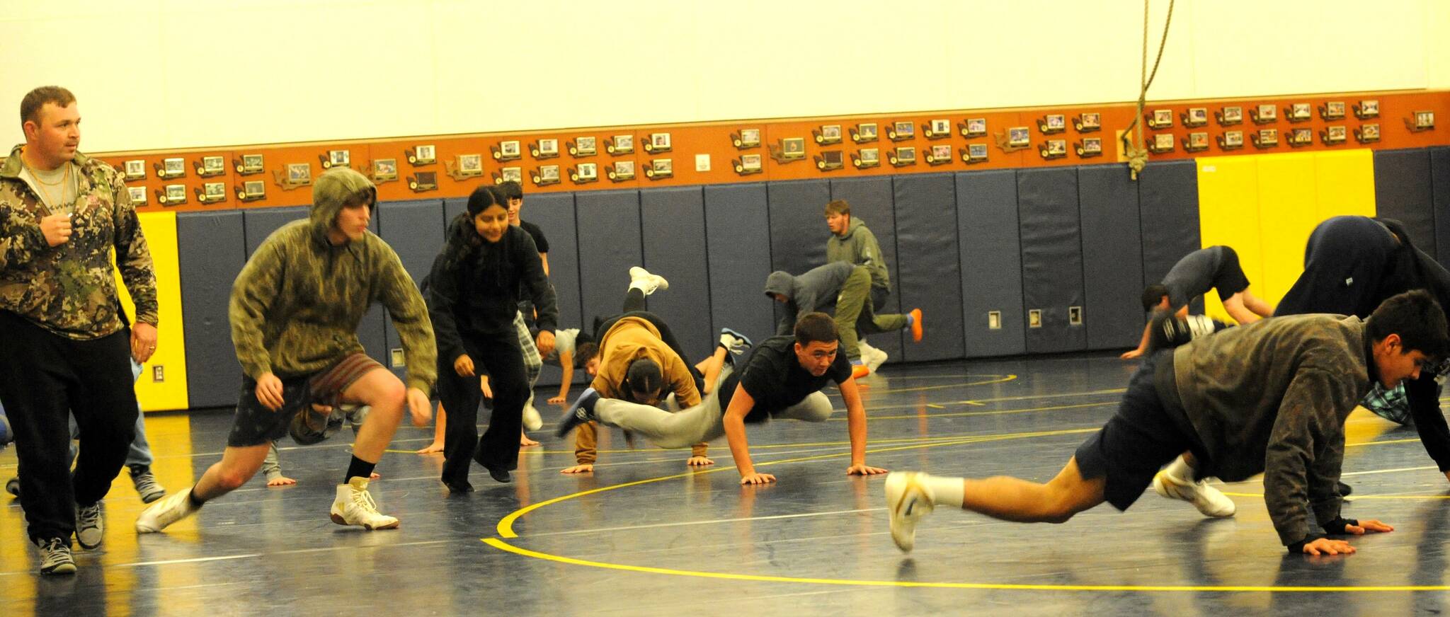 Forks’ head wrestling coach, Tanner House (left), leads the Spartans through drills for the upcoming season, which is scheduled to begin in Port Townsend on Wednesday, Dec. 3 at 5 p.m. Forks is scheduled to compete with Port Angeles at home on Dec. 6, TBA. In wrestling, it is always possible for other teams to be added to the tournaments. 
Photo by 		Lonnie Archibald