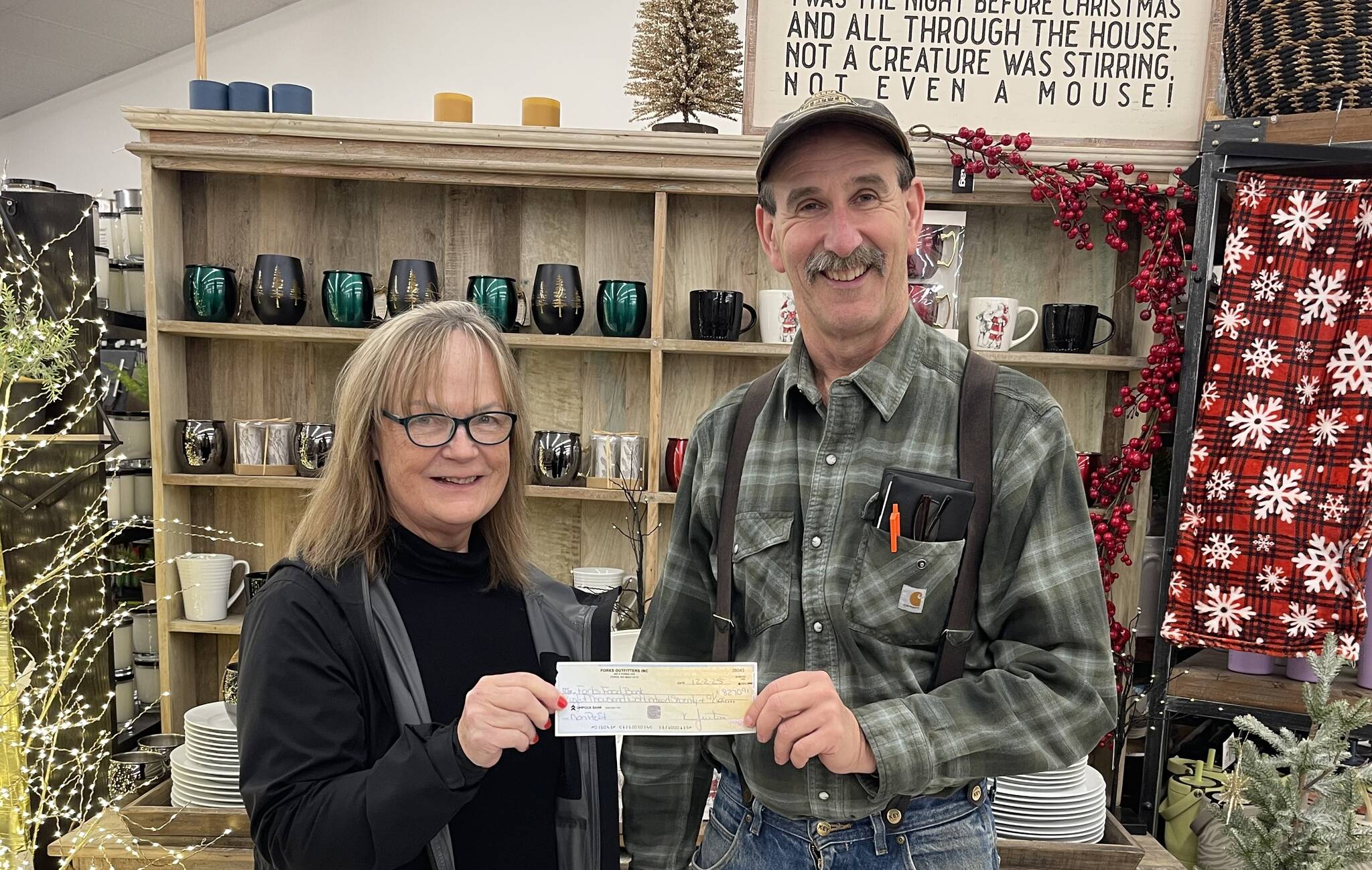 Photo Christi Baron
If yourounded up your purchase this holiday season at Outfitters …thank you! Those few cents here and a few dollars there resulted in $8,270.91 being raised for our local food bank. Outfitters owner Bruce Paul recently presented Forks Food Bank Director Pat Soderlind with a check. Paul also shared that the store matches the amount customers donated! Seen in the photo - Pat and Bruce with the check.