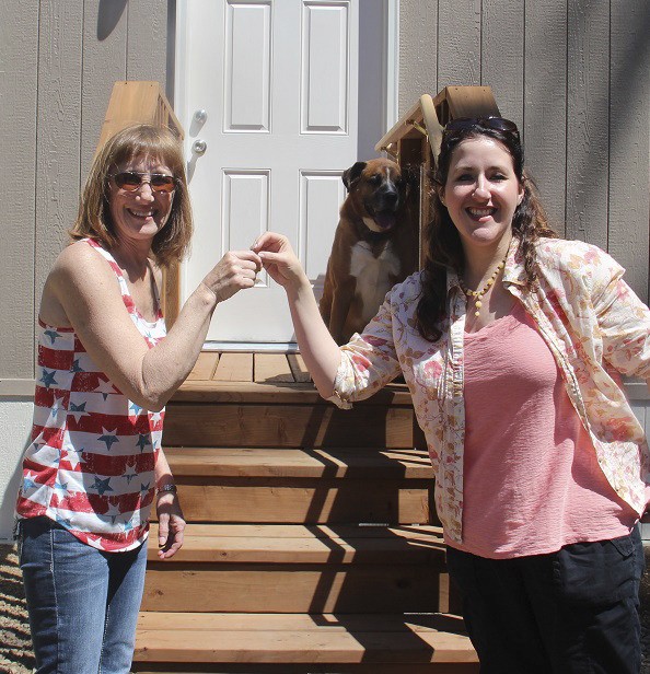 Joni Evans receives the keys to her new home from Laura Capo as Gunnar looks on.