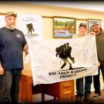 Scooter Lewis WWP Alumni manager presents Calm Waters VP Ted Bates and Sgt-at-Arms Bob Bingham, with a signed WWP flag.