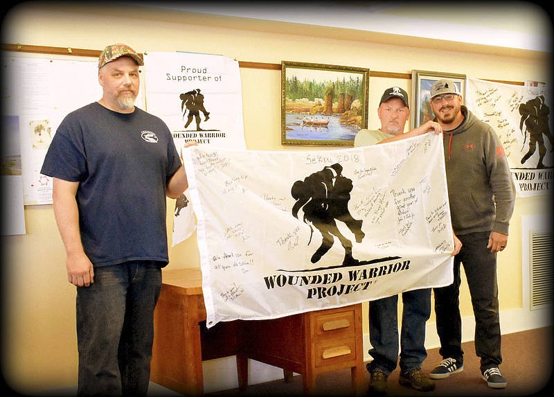 Scooter Lewis WWP Alumni manager presents Calm Waters VP Ted Bates and Sgt-at-Arms Bob Bingham, with a signed WWP flag.
