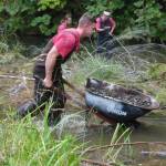 OCC inmate crew member places a wheelbarrow full of gravel in the creek. Photos David Hahn