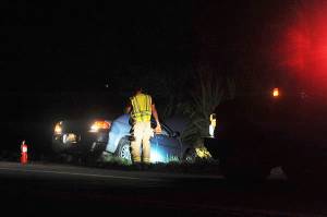 A fireman looks over the scene near mile marker 200 at approximately 10 p.m. Wednesday, Sept. 26, along highway 101 where this vehicle went off the roadway into the ditch. Photo by Lonnie Archibald