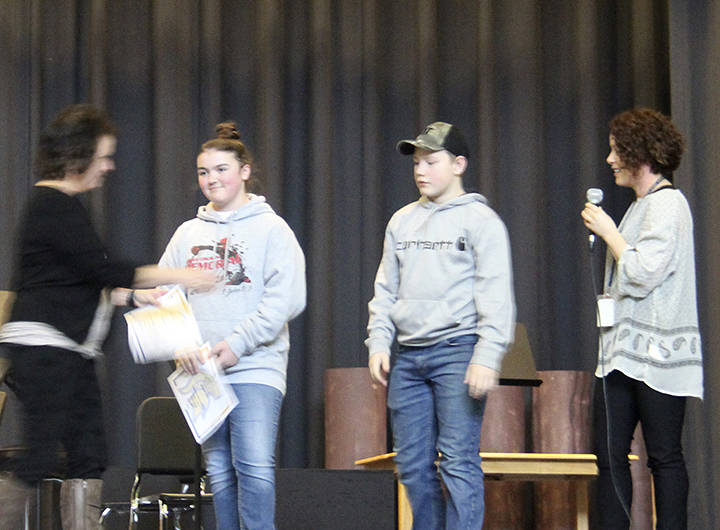 Sarah Decker makes the announcement as School Superintendent Diana Reaume congratulates Rowan Ball and Nate Dahlgren on achieving 4.0s for both first and second quarters. Also achieving a 4.0 for both quarters but not pictured was Keira Johnson.