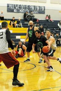 Olympic Sporting Goods ex-Spartans Kasey Ulin (left) and DJ Huggins look on while another ex-Spartan Jordan Justus drives the key Sunday during the Nate Crippen Memorial Basketball Tournament in Forks. The Olympic Sporting Goods defeated Black Diamond Electric 69-61 to take the championship. Photo by Lonnie Archibald