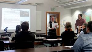 Paul Bialkowsky speaking and Matt Comisky looking on as the two spoke to about 25 people at the ONRC last Tuesday evening. They shared the purpose, key goals and mission of the Olympic Peninsula Collaborative. Photo by Christi Baron