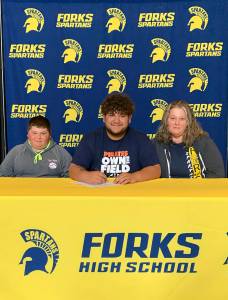Forks Spartan Iziah Morton signs and is joined by younger brother Daniel Ferreyra and his mother Tauna Morton. Submitted Photo