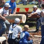 Smokey Ellison and Wade Parker take their turn at the saw, as the Krumes look on.