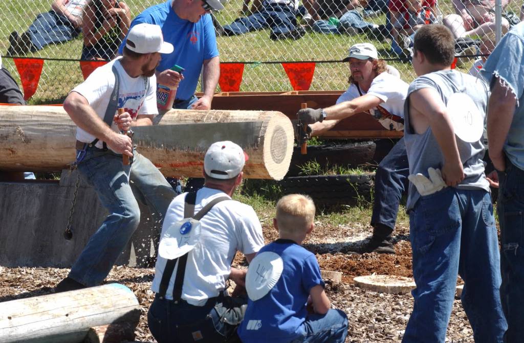 Smokey Ellison and Wade Parker take their turn at the saw, as the Krumes look on.