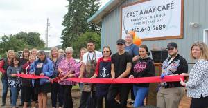 Linda Middleton, center with scissors, cuts the ribbon last Wednesday as the Cast Away Cafe opens for business. Photo Christi Baron