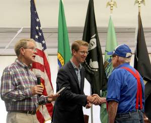 Forks resident Dave Hersom was the first veteran up to receive a pin as Clallam County Commissioner Randy Johnson reads out his name and service information Dave shakes hands with Rep. Derek Kilmer. Photo Christi Baron