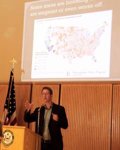 Representative Derek Kilmer stands in front of a slide of a US map showing the areas in our country that are booming, stagnant and some that are worse off, as he spoke to a group of about 50 people at a Town Hall meeting at the Rainforest Arts Center last Wednesday evening. Photo Christi Baron