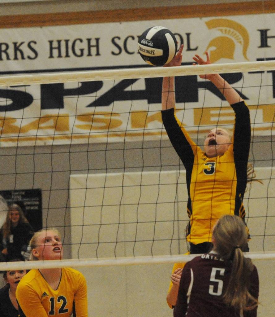 Spartan JV player Kadie Wood (3) goes high to block a Hoquiam hit during a recent contest with the Grizzlies. Forks took two of the three sets. Also in on the action for Forks is Kesia Rowley (12). Photo by Lonnie Archibald