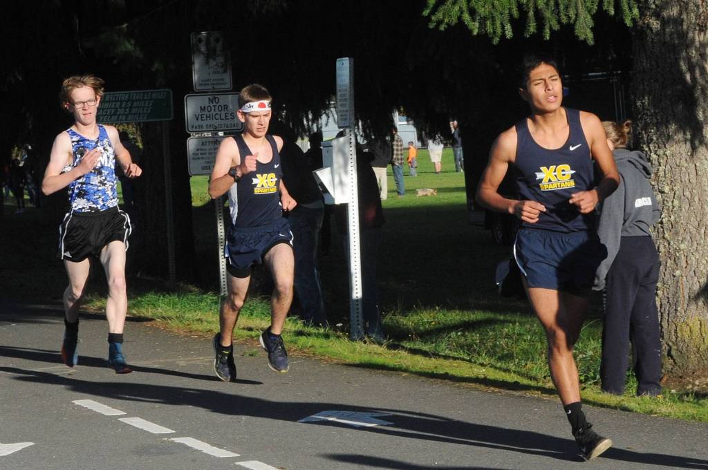 Pictured here In a recent Evergreen League meet in Tenino Spartans Wesley Camacho (leading) and Matthew Larson compete with Elma, Hoquiam, Montesano and Tenino in the 5K race. The boys race results were not posted due to half of the racers running the short 1.5 mile route in a course mix up. In the girls race Spartan Madelyn Archibald took first with teammate Karen Ensastegui Salazar finishing third. Photo by Lonnie Archibald