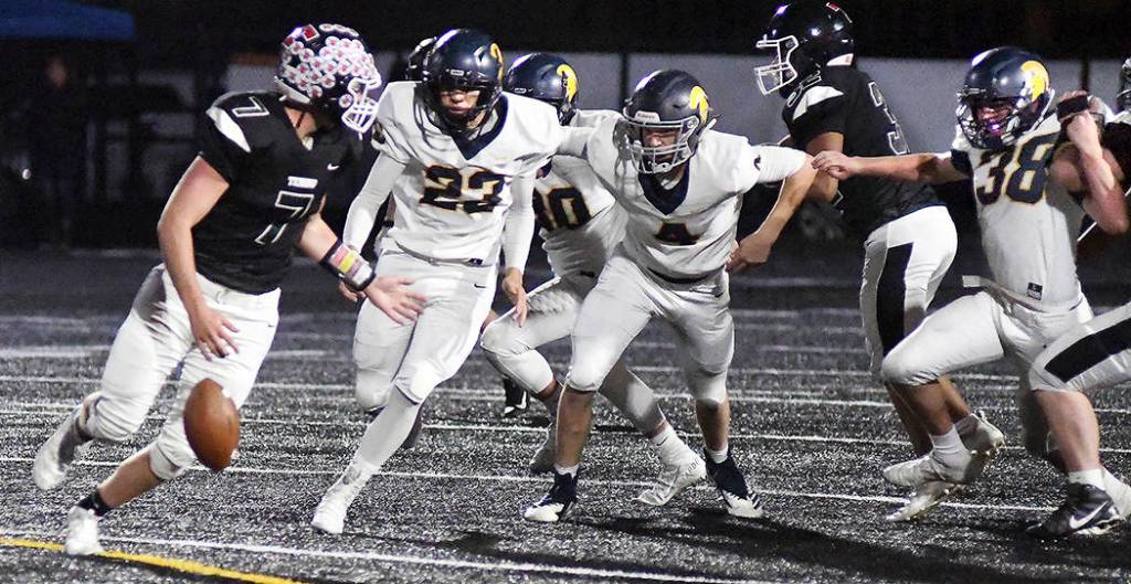 Forks defenders, from left, Elijah Tabor, Carter Windle, and Hayden Queen close in as Paxton Russell of Tenino fumbles the ball during the Spartans 45-13 win on Saturday in Tenino. Photo by Mike Salsbury for The Forks Forum.