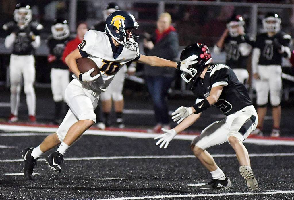 Logan Olson of Forks stiff arms a Tenino player en route to a first quarter touchdown during the Spartans 45-13 win on Saturday in Tenino. Photo by Mike Salsbury for The Forks Forum