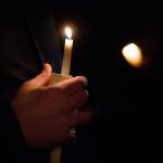 Spartans football coach Emil West holds a candle as he speaks about Tristen Pisani during the vigil for Pisani on Thursday. (Jesse Major/Peninsula Daily News)