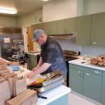 Eugene Fraker is seen here preparing meals for the weekly Feeding 5000 free lunch activity at the Community Center on Maple Ave. Thanks to a generous donation from the Lloyd Allen Charitable Trust Fund a new kitchen appliance, seen at the back left of the photo, is helping Fraker bake homemade bread. Fraker and others volunteer each week to provide a noon meal to many West End residents, in recent weeks about 200 lunches each Tuesday. Photo Don Grafstrom