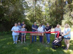Janice Winney Lichtenwaldt was joined by family and friends last Saturday for a Forks Chamber of Commerce Ribbon Cutting ceremony at her new business venture The Virago Retreat Center located off Smith Rd. near the Hwy 101 Bogachiel Bridge. Janice, seen here in the center of the photo, was joined by Jack Banner for the ribbon cutting action. Photo Christi Baron