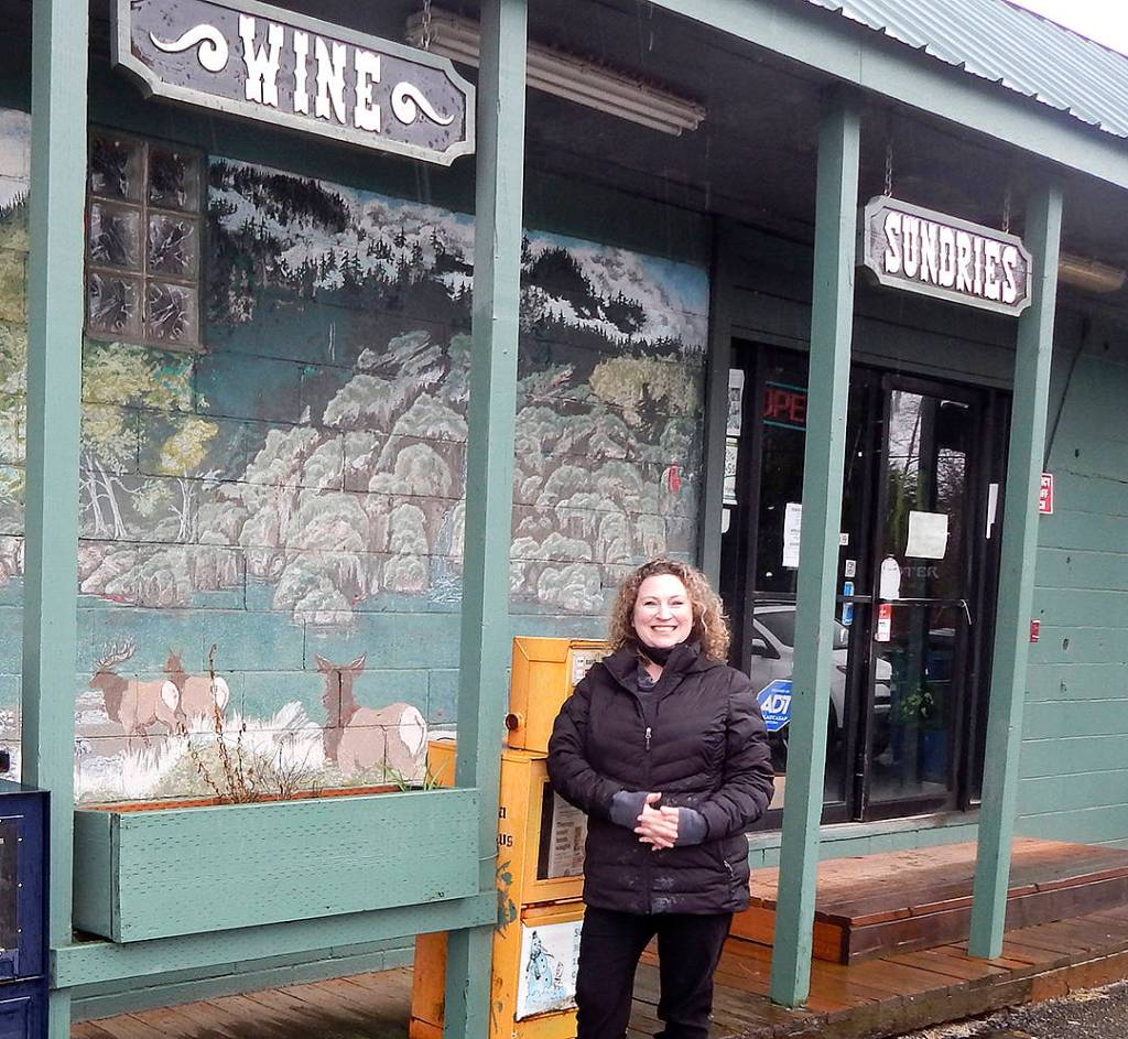 Carrie Dahlgren Merrill stands outside the future Beaver Grocery Store. Plans include touching up the mural behind her. Photo Christi Baron